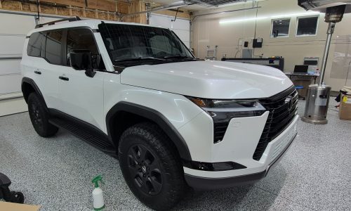 White SUV receiving professional auto restyling and protection services in Colorado Springs